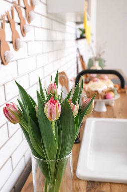 Paskalya kutlaması için mutfakta güzel lale çiçekleri olan vazo, yakın plan.