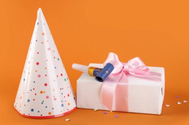 Parti şapkası, hediye kutusu ve arka planda ıslık