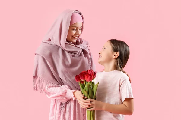Little Girl Tulips Her Muslim Mother Pink Background — Zdjęcie stockowe