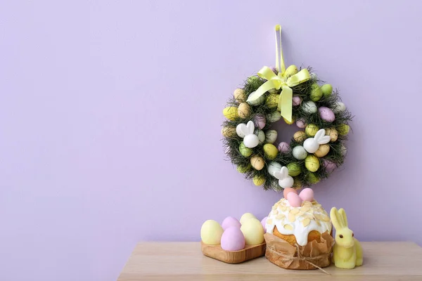 Tisch Mit Osterkuchen Eiern Hase Und Kranz Lila Wand — Stockfoto