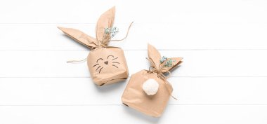 Beyaz tahta arka planda Paskalya tavşanı hediye paketleri