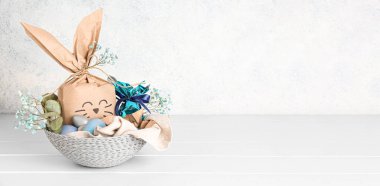 Paskalya tavşanı hediye paketi ve açık arkaplanda mesaj için yeri olan yumurtalar.
