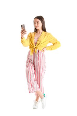 Beyaz arka planda akıllı telefonu olan güzel bir genç kadın.