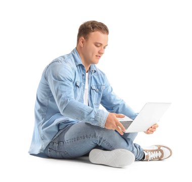 Beyaz arka plan üzerinde dizüstü bilgisayar kullanan genç adam