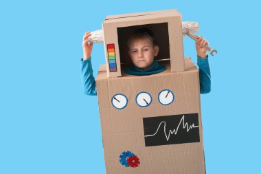 Mavi arka planda karton robot kostümlü küçük çocuk.