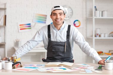 Masanın yanındaki erkek ressam.