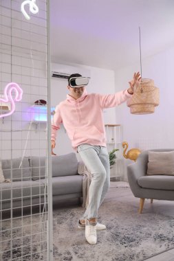 Young man using VR glasses at home