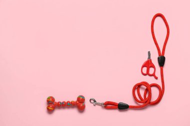 Tasmalı kompozisyon, tırnak makası ve pembe arka planda lastik oyuncak