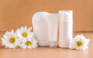 Renkli arka planda kozmetik ürünleri ve papatya çiçeği seti