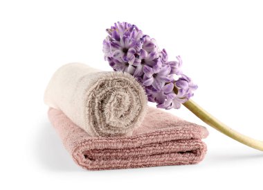 Temiz yumuşak havlular ve beyaz arka planda izole edilmiş sümbül çiçeği.