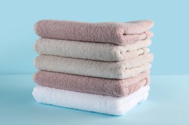 Mavi arkaplanda katlanmış yumuşak havlu yığını