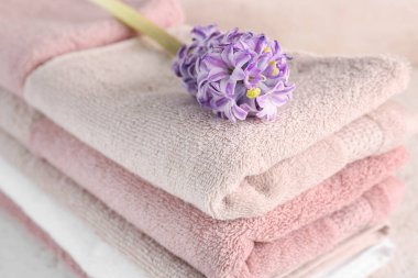 Masada katlanmış yumuşak havlular ve sümbül çiçeği yığını.