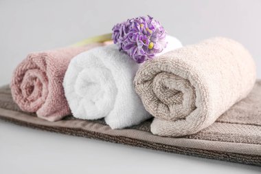 Temiz yumuşak havlular ve gri arka planda sümbül çiçeği.