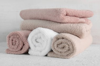 Tahta duvarın yanındaki beyaz masada temiz yumuşak havlular.