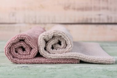 Yeşil ahşap masada yuvarlanmış yumuşak havlular.