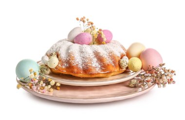 Beyaz arka planda lezzetli Paskalya pastası, yumurta ve çigila çiçekli tabak.