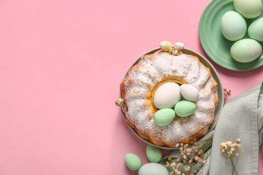 Composition with tasty Easter cake, painted eggs and gypsophila flowers on pink background