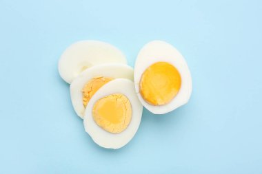 Mavi arka planda dilimlenmiş haşlanmış yumurta.