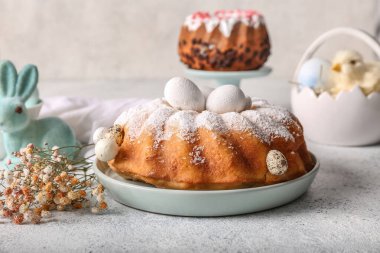 Lezzetli Paskalya pastası, yumurta ve gri masada güzel çigila çiçekleri.