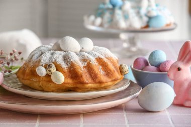 Lezzetli Paskalya pastası ve pembe fayansların üzerine boyanmış yumurtalar.
