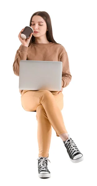 一个年轻漂亮的女人 带着笔记本电脑和咖啡 靠着白色的背景坐在椅子上 — 图库照片