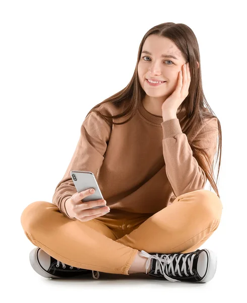 Hübsche Junge Frau Mit Smartphone Sitzt Vor Weißem Hintergrund — Stockfoto