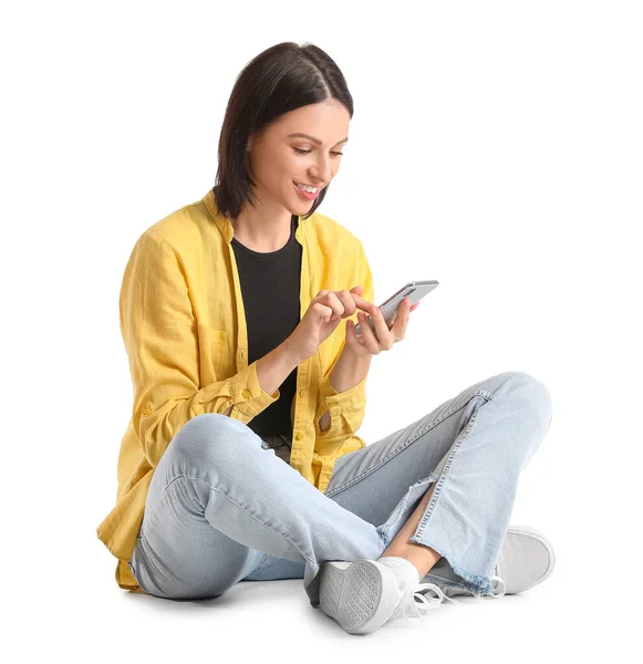 Hübsche Junge Frau Mit Smartphone Sitzt Vor Weißem Hintergrund — Stockfoto