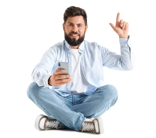 Junger Bärtiger Mann Mit Handy Zeigt Auf Etwas Auf Weißem — Stockfoto