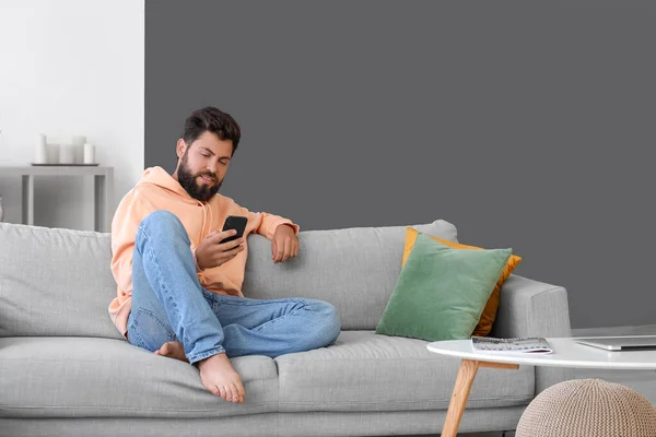 Handsome Bearded Man Using Mobile Phone Grey Sofa Home — Stock Photo, Image