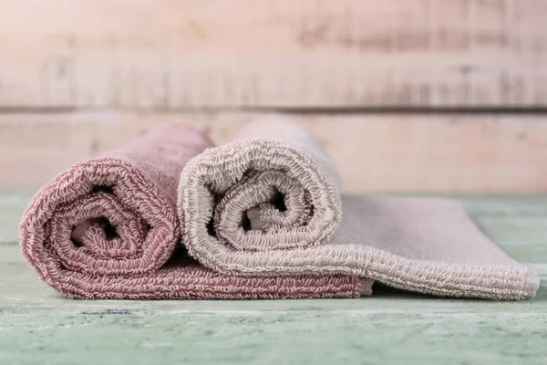 Rolled soft towels on green wooden table