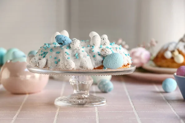 Dessertstand Mit Leckerem Osterkuchen Und Bemalten Eiern Auf Rosa Fliesentisch — Stockfoto