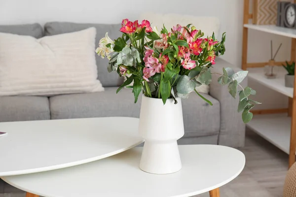 リビングでテーブルの上に美しいアロステミアの花の花束と花瓶 — ストック写真