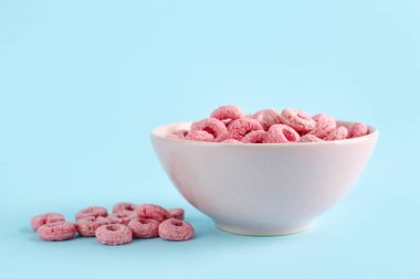 Mavi arka planda bir kase pembe gevrek halkası