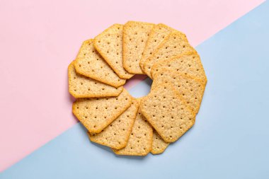 Pembe ve gri arka planda lezzetli krakerlerden yapılmış daire