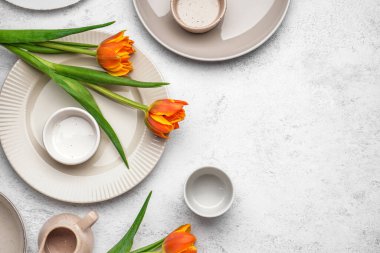 Beyaz grunge arka planda, temiz tabaklar ve güzel lale çiçekleriyle kompozisyon