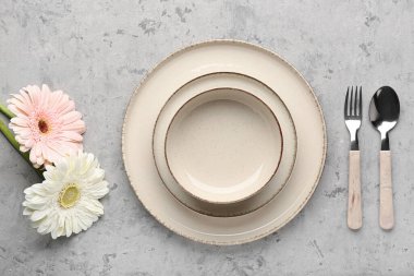 Gri grunge arka planda güzel Gerbera çiçekleri olan masa ayarı