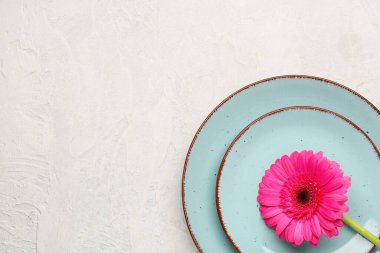 Beyaz grunge arka planda güzel gerbera çiçekli masa ayarı