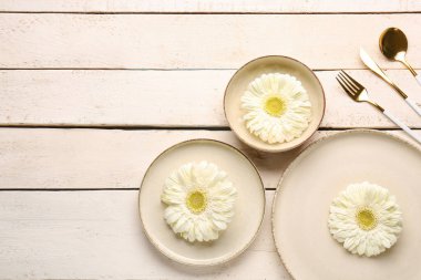 Bej ahşap arka planda güzel Gerbera çiçekleri olan masa ayarı