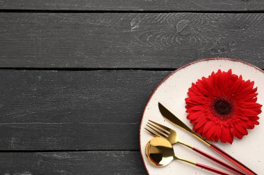 Siyah ahşap arka planda güzel Gerbera çiçekleri olan masa ayarı