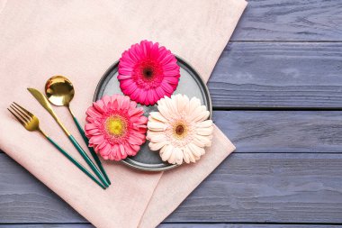 Gri ahşap arka planda güzel Gerbera çiçekleri olan masa ayarı