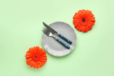 Yeşil arka planda güzel Gerbera çiçekleri olan masa ayarı