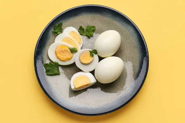 Placa Con Deliciosos Huevos Cocidos Perejil Sobre Fondo Amarillo — Foto de Stock