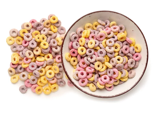 Bowl and heap of colorful cereal rings isolated on white background