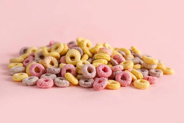 Heap of colorful cereal rings on pink background