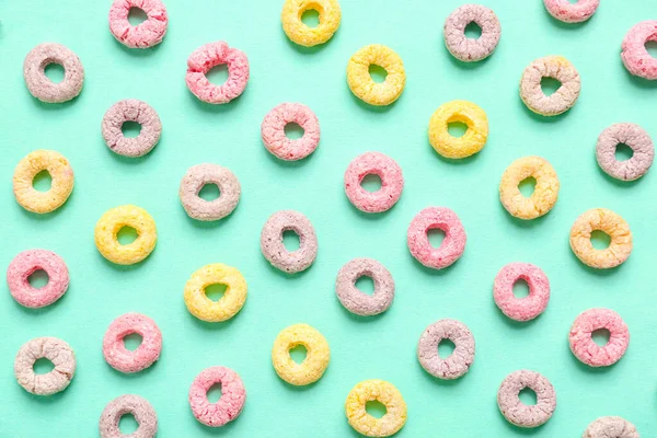 Many colorful cereal rings on turquoise background