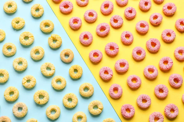 Many colorful cereal rings on blue and yellow background