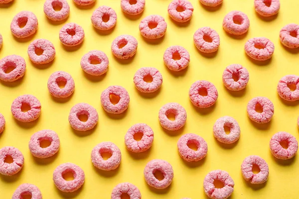 Many pink cereal rings on yellow background