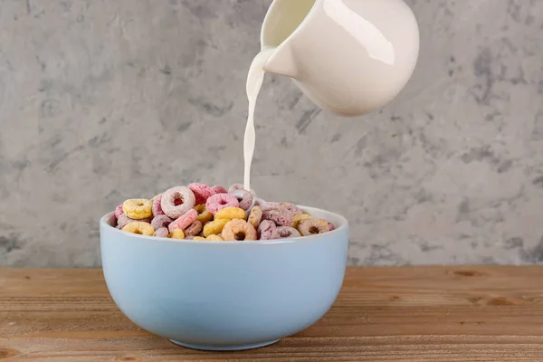 Pouring Milk Pitcher Bowl Colorful Cereal Rings Wooden Table Grey — Stock Photo, Image
