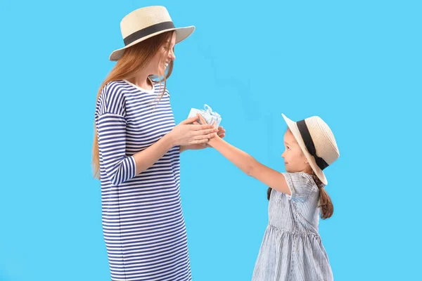 Schattig Klein Meisje Groeten Haar Moeder Met Geschenk Blauwe Achtergrond — Stockfoto