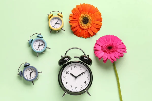 Alarm Clocks Beautiful Gerbera Flowers Green Background — Stock Photo, Image